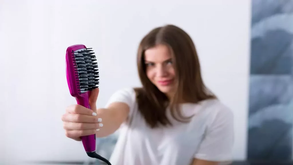 Abertura do post sobre como usar escova alisadora: Mulher mostrando escova alisadora em destaque
