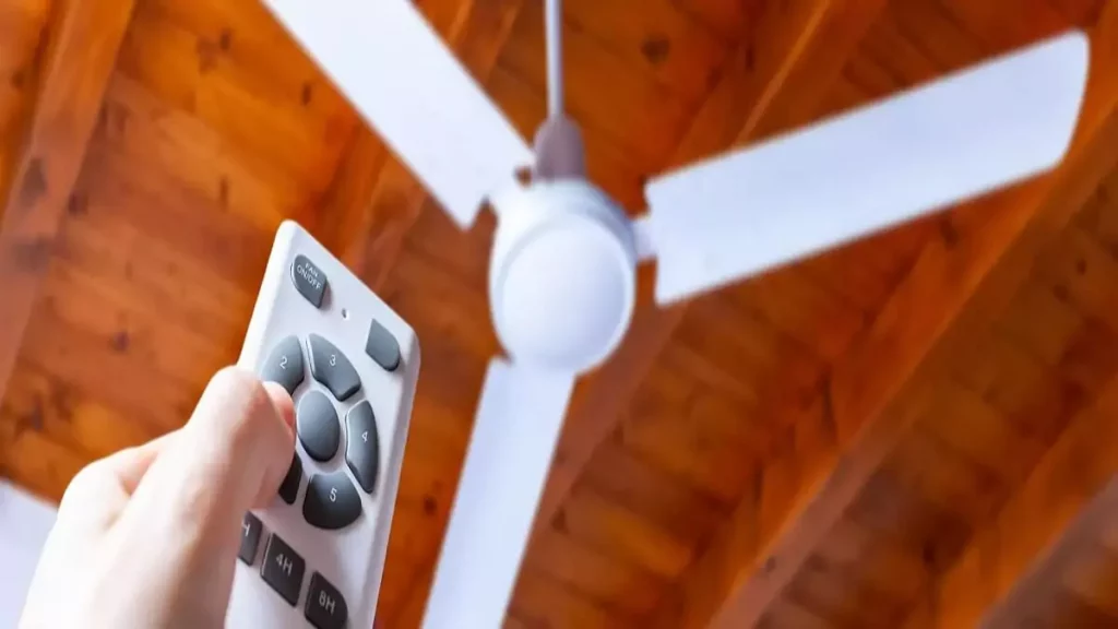 Abertura do post sobre como usar ventilador de teto: Homem acionando controle remoto do ventilador