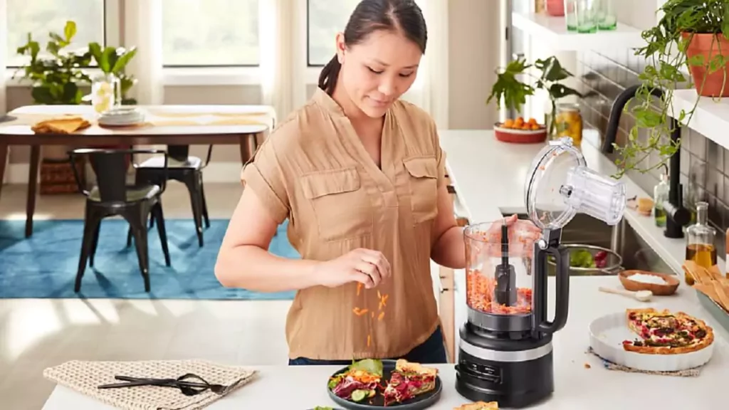 Abertura do post sobre como usar processador de alimentos: Mulher fatiando legumes com multiprocessador